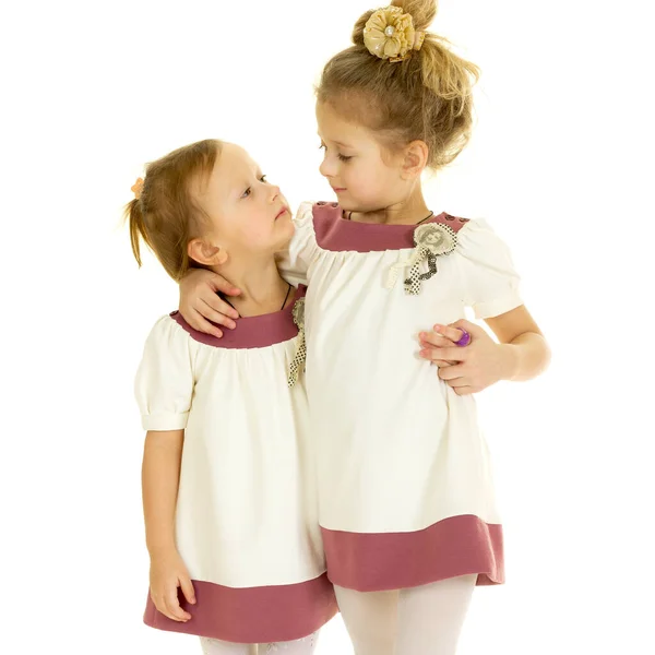Sevimli şirin küçük kız kardeşler ayakta ve sarılıyorlar — Stok fotoğraf