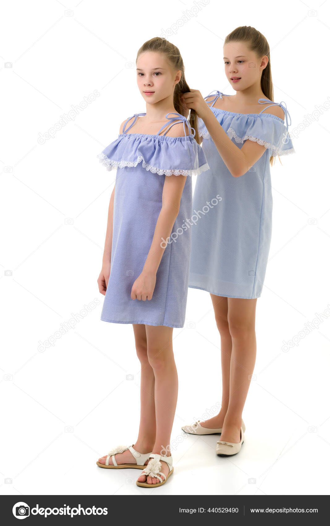 Hermanas Gemelas en Vestidos Ligeros Identicos Chica Trenzando su Siste Foto de stock 440529490 lotosfoto1