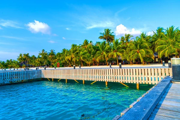 Puentes de madera que conducen a las cabañas a orillas del mar tropical y cálido. Maldivas. Concepto turístico. — Foto de Stock