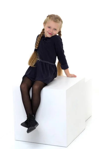 Чарівна маленька дівчинка позує на білому кубі . — стокове фото