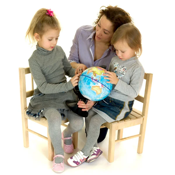Maman et ses petits enfants assis avec globe — Photo