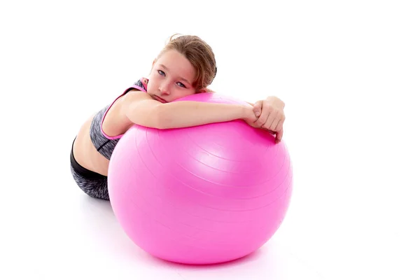 Niña haciendo ejercicios en una pelota grande para la aptitud. — Foto de Stock