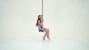 Şirin Mutlu Kız İpte Oturuyor Sallanıyor ve Yukarı Bakıyor