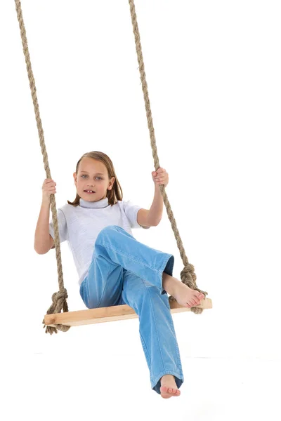 Blonde girl swinging on rope swing — Stock Photo, Image