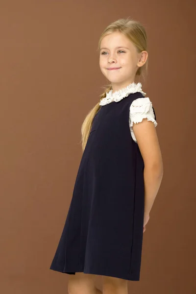 Aranyos szőke lány iskolai egyenruhában. — Stock Fotó
