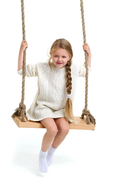 Mignon fille aux cheveux longs assis sur corde swing — Photo