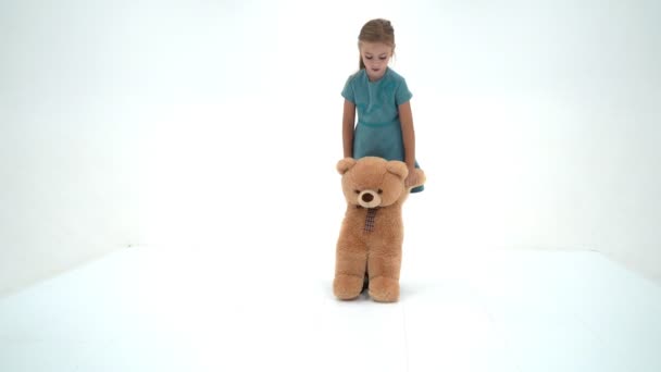 Klein meisje met teddybeer. Op witte achtergrond. — Stockvideo