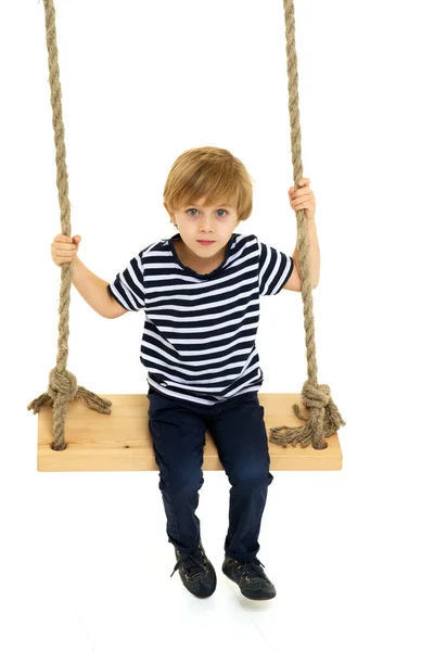 Roztomilý chlapec sedí na laně houpačka — Stock fotografie