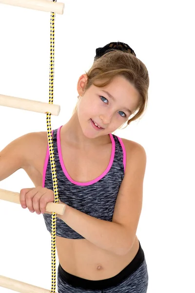 Chica realizando ejercicio gimnástico en la escalera de cuerda. — Foto de Stock