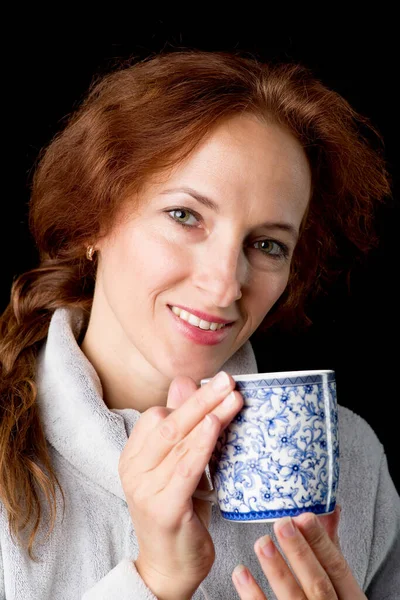 Mulher segurando caneca em suas mãos — Fotografia de Stock