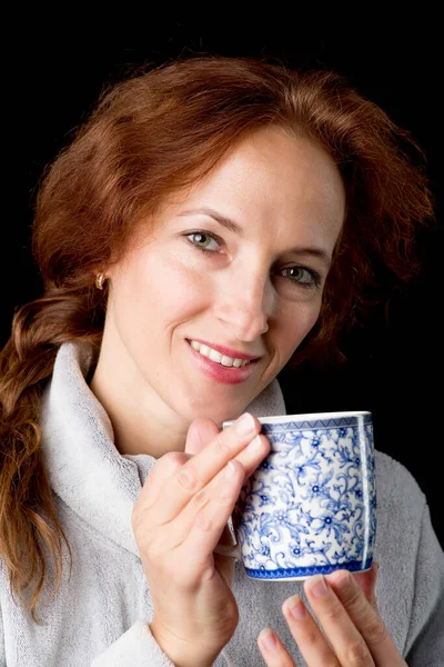 Woman holding mug in her hands Stock Picture