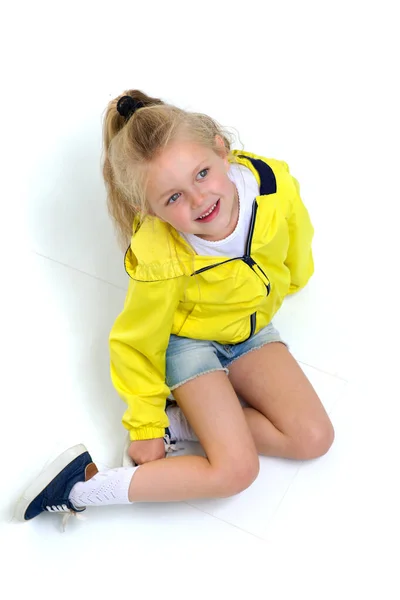 Šťastná šestiletá dívka sedící na podlaze — Stock fotografie