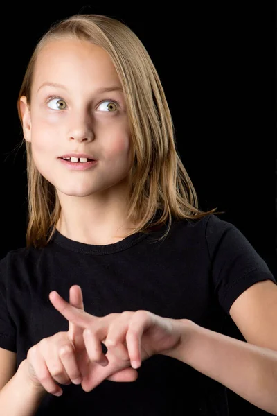 閉じる上のポートレートの十代の女の子で黒tシャツジェスチャーで黒の背景. — ストック写真