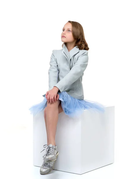 Menina bonita sentada no cubo branco — Fotografia de Stock