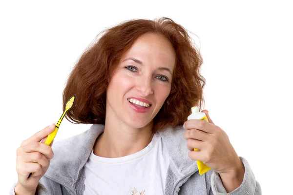 Kobieta trzymająca szczoteczkę do zębów i pastę do zębów — Zdjęcie stockowe
