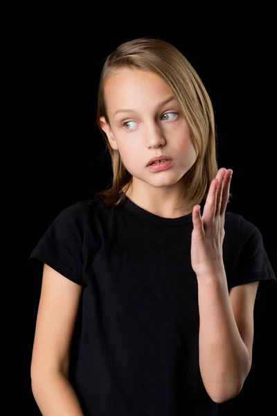 閉じる上のポートレートの十代の女の子で黒tシャツジェスチャーで黒の背景. — ストック写真