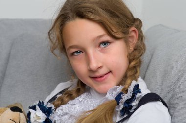 Kanepede oyuncak ayıyla oturan tatlı liseli kız