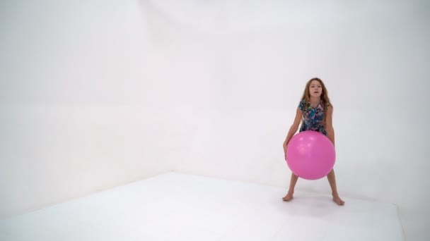 Petite fille joue avec une ballle.Le concept de sports pour enfants, loisirs de plein air d'été. — Video