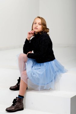 Beyaz küpün üzerinde oturan güzel kız