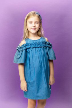 Mavi kot elbiseli gülümseyen kız. Stüdyoda fotoğraf çekimi.