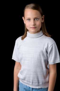 Siyah arka planda poz veren sevimli, gülümseyen küçük bir kızın yakın görüntüsü.