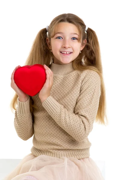 Menina bonita segurando coração vermelho. Retrato de estúdio. — Fotografia de Stock