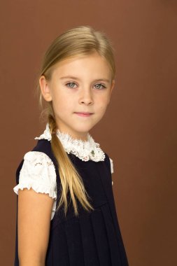 Üniformalı sevimli, neşeli kız öğrenci. Stüdyoda fotoğraf çekimi.