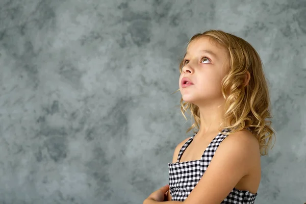 Het kleine meisje kijkt op.Het concept van kinderen emoties. — Stockfoto