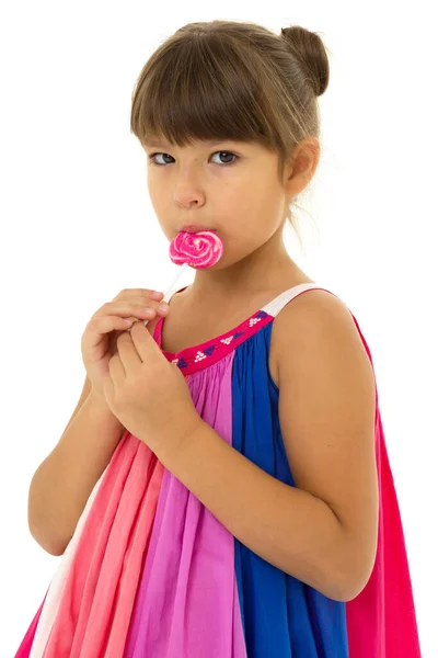 Cute little girl licking lollipop. Photo session in the studio — Stock Photo, Image