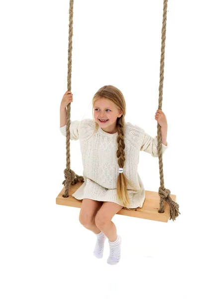 Χαριτωμένο μακρυμάλλη κορίτσι κάθεται στην κούνια σχοινί — Φωτογραφία Αρχείου