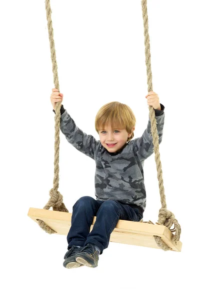 Lindo chico sentado en cuerda swing — Foto de Stock