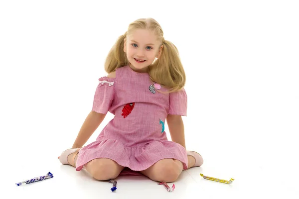 A menina é um dente doce, ela está muito feliz com os doces. — Fotografia de Stock