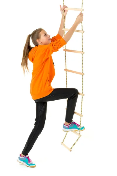 Menina adolescente escalando escada corda. Isolado sobre fundo branco. — Fotografia de Stock