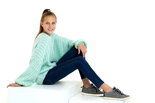 Усміхнена дівчинка-підліток сидить на підлозі. Ізольовані на білому тлі . — стокове фото