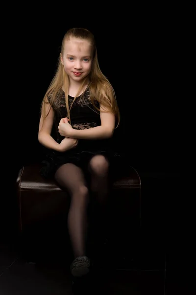 Uma linda menina endireita o cabelo na cabeça. — Fotografia de Stock