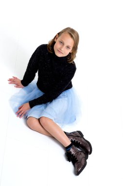 Güzel sarışın stüdyoda yerde oturuyor.