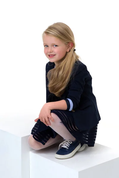 Meisje in schooluniform zittend op de vloer — Stockfoto