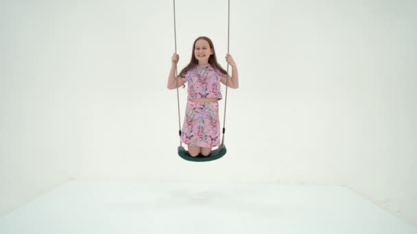 可爱的快乐女孩坐在绳子上荡秋千，抬头看 — 图库视频影像