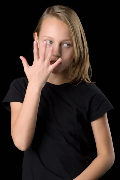 Primer plano retrato de adolescente en camiseta negra gesticulando sobre fondo negro. — Foto de Stock