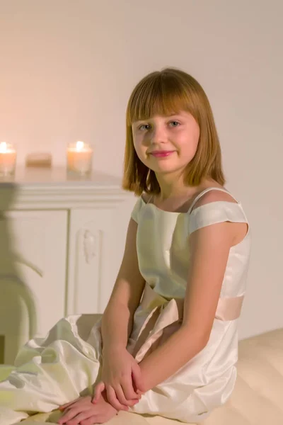 Маленькая девочка в темной комнате при свечах. — стоковое фото