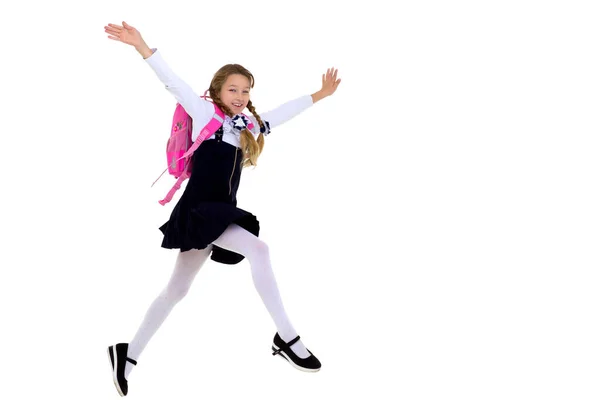 Улыбающаяся школьница счастливо прыгает высоко — стоковое фото