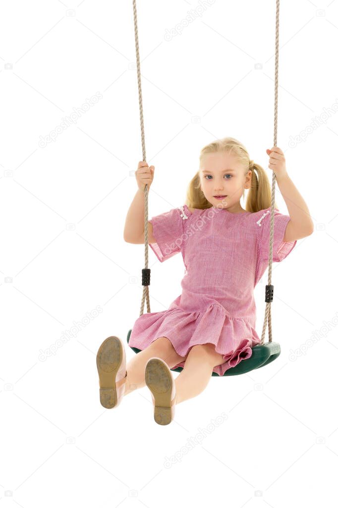Beautiful teen school girl swinging on a swing. Concept summer vacation.