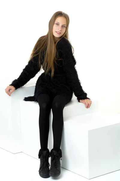 Ευτυχισμένο έφηβο κορίτσι κάθεται σε λευκό κύβο — Φωτογραφία Αρχείου