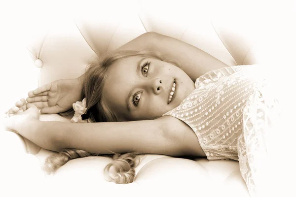 Adorable chica sonriente acostada en el sofá — Foto de Stock