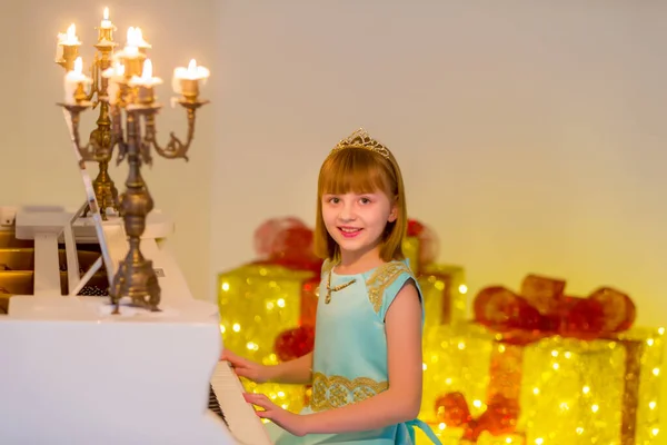 Маленькая девочка играет на пианино при свечах. — стоковое фото