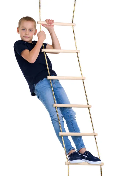 Tienerjongen klimt op touwladder — Stockfoto