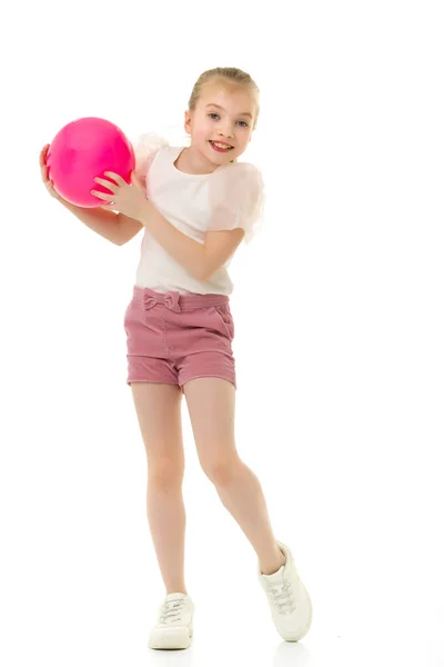 Liten flicka leker med en stor boll för fitness — Stockfoto