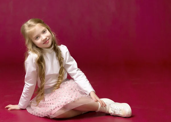 La niña está sentada en el suelo.El concepto de un niño feliz — Foto de Stock