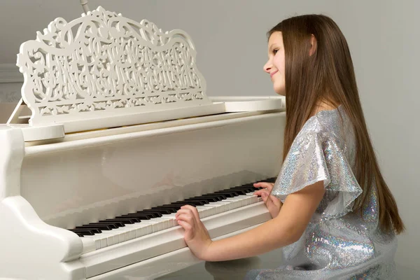 Красивая девочка-подросток играет на рояле — стоковое фото