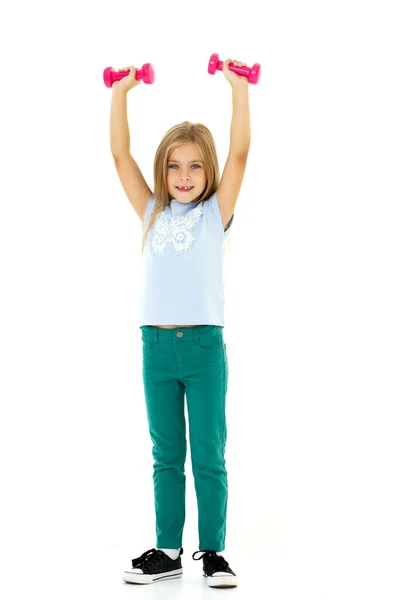 Little girl doing exercises with dumbbells. — Stock Photo, Image